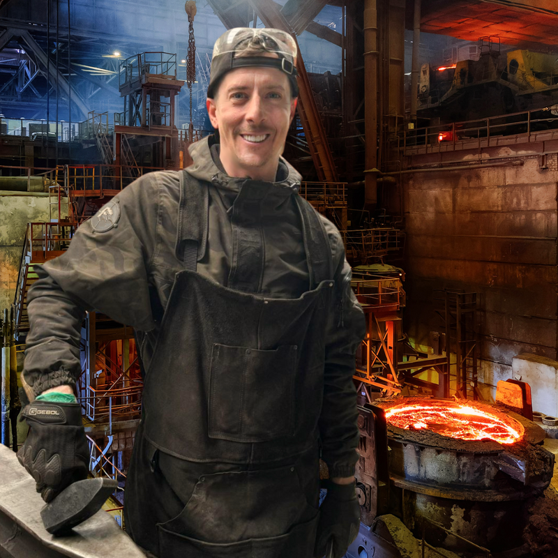 Schmied in Schutzkleidung vor glühender Esse in der Werkstatt – Schmiedekurs bei Damastique, Österreich.